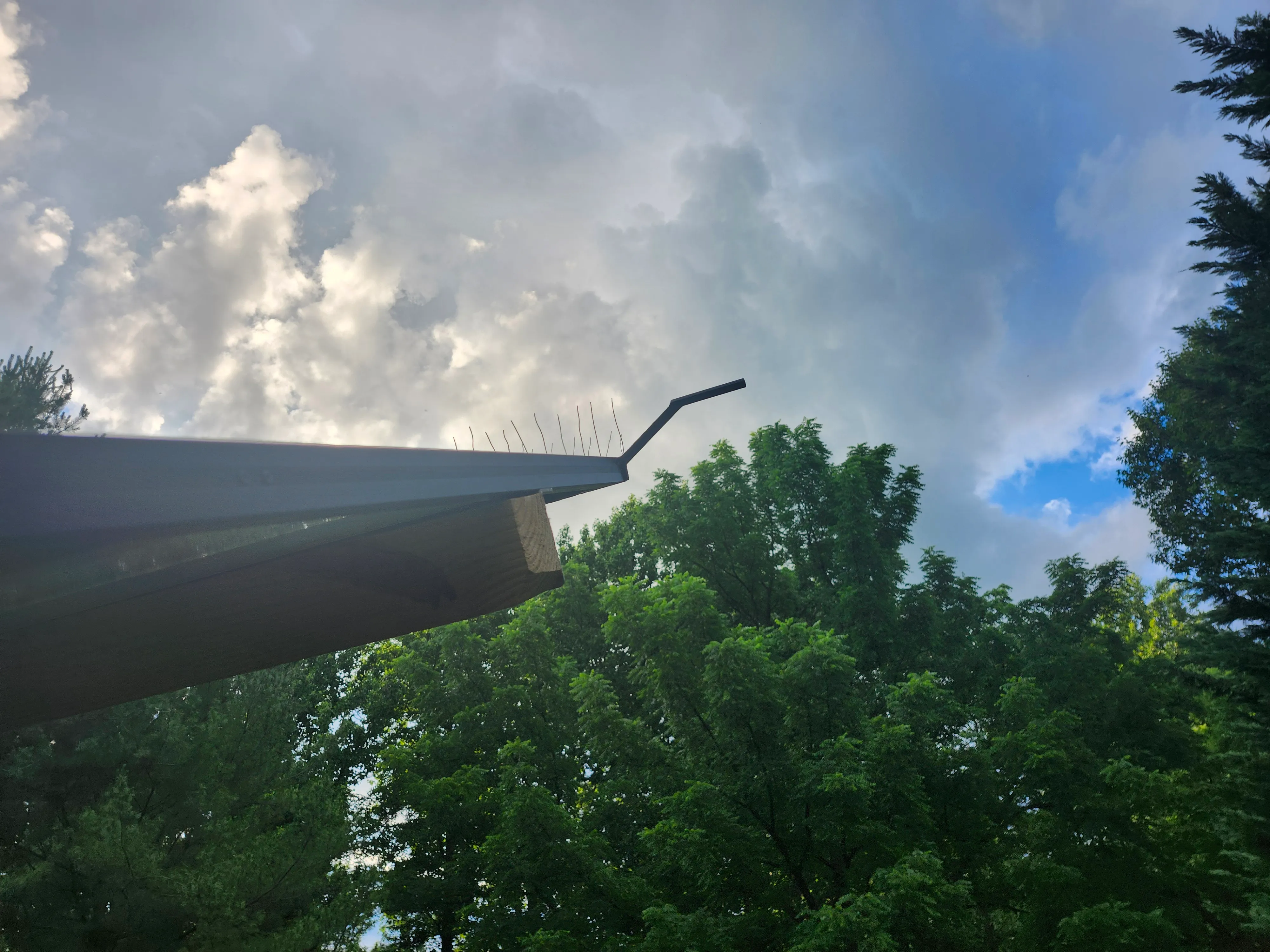 The PerchOff offset perch arm extending past the panel edge against a cloudy sky